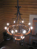 Forged chandelier stylized as a cart wheel.